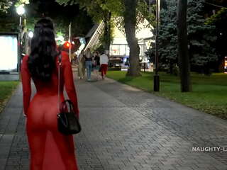 穿着纯粹的红色连衣裙的户外暴露主义者
