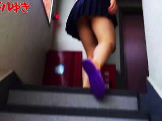 Vista por debajo de la falda de una niña japonesa subiendo escaleras